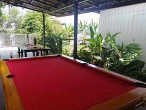 a red pool table in a yard with a table at Downtown cabin for families in Macas in Macas