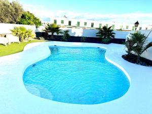 a swimming pool with blue water in a backyard at Oasis 138 in Playa Blanca