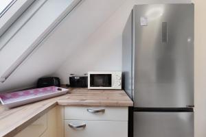 a kitchen with a refrigerator and a microwave at 3 Raum Ferienwohnung Im 1 Og in Cuxhaven