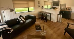 a living room with a black couch and a table at Caol Ila - Lodge 8 in Stranraer +16 photos
