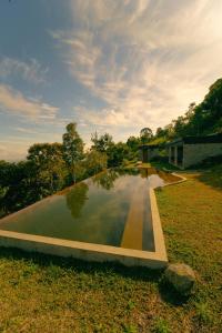 una grande piscina d'acqua in un campo di Refúgio Contemporâneo na Serra da Bocaina a Silveiras