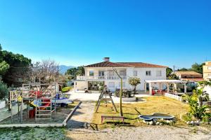 a house with a playground in front of it at Kuko Beach Denia in Denia