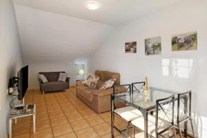 Una sala de estar con un sofá y una mesa de cristal. en Montemar 1, en Moya