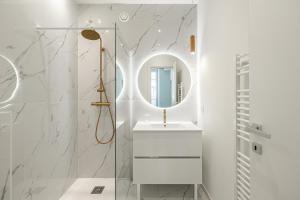 ein Badezimmer mit Waschbecken und Spiegel in der Unterkunft Cannes City Suites - 4 appartements neufs au coeur de Cannes in Cannes + 36 Fotos