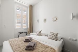 ein weißes Schlafzimmer mit einem großen Bett mit Handtüchern darauf in der Unterkunft Cannes City Suites - 4 appartements neufs au coeur de Cannes in Cannes