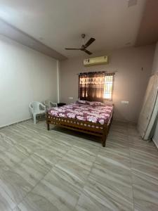 Un dormitorio con una cama y un ventilador de techo. en Neelkanth Villa, en Ahmedabad
