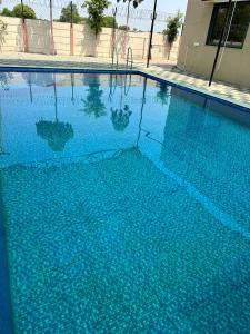 una gran piscina con agua azul en Neelkanth Villa, en Ahmedabad