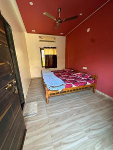 Un dormitorio con una cama en una habitación con paredes rojas. en Neelkanth Villa, en Ahmedabad