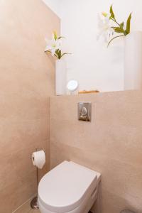 a bathroom with a toilet and flowers on the wall at LuxArt City Spa Gallery Residence Krk in Krk +32 photos