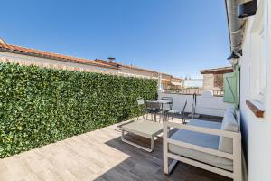 einen Balkon mit Stühlen und einer grünen Hecke in der Unterkunft Cannes City Suites - 4 appartements neufs au coeur de Cannes in Cannes