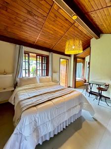 a bedroom with a large bed with a wooden ceiling at Recanto Meu Pedacinho de Chão in Visconde De Maua