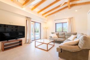 un salon avec un canapé et une télévision dans l'établissement Villa Lorena, à Ses Salines