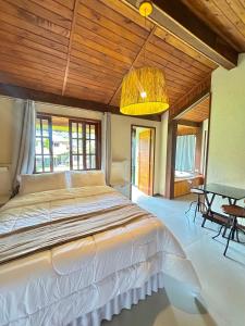 a bedroom with a large bed and a table at Recanto Meu Pedacinho de Chão in Visconde De Maua