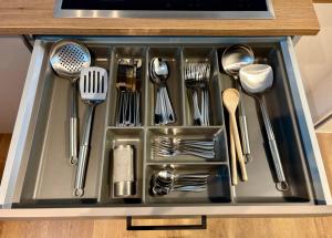 a metal sink with utensils in it at NEW! StayPfalz Apartment - 3 Zimmer & Parkplatz in Neustadt an der Weinstraße