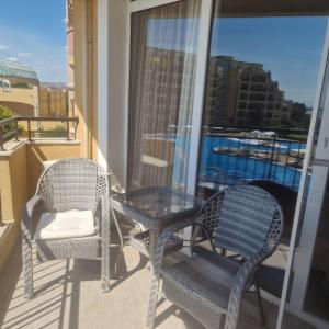two chairs and a glass table on a balcony at Charming Studio at the Seaside in Aheloy
