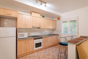 a kitchen with wooden cabinets and a white refrigerator at Chalet Limonita in Mutxamel