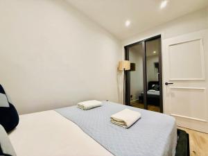 a bedroom with a bed with two towels on it at Old Compton Apartments in London +4 photos