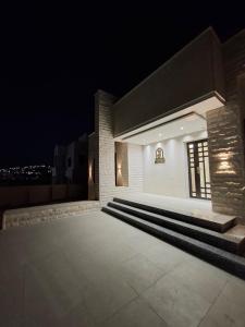 een nachtzicht op een gebouw met een aantal trappen bij Jeeso hotel in Jerash
