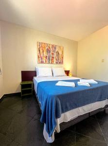 a bedroom with a large bed with a blue blanket at Pousada Céu de Estrelas in Bonito +57 photos
