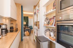 a kitchen with white cabinets and a counter at LuxArt City Spa Gallery Residence Krk in Krk