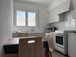 a kitchen with white cabinets and a table and a window at Holiday Home Villa Guapa in L'Estartit