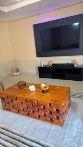 una mesa de centro de madera en la sala de estar con TV en Sazeesha Apartments, en Ndola