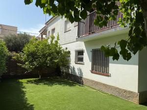 a building with a green yard with a hose at Holiday Home Villa Guapa in L'Estartit