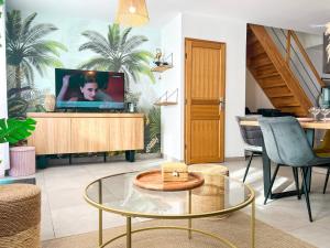 ein Wohnzimmer mit einem TV und einem Glastisch in der Unterkunft Maison 6 personnes - Etaples in Étaples + 18 Fotos