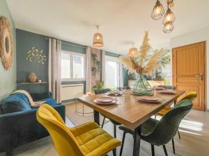 ein Wohnzimmer mit einem Holztisch und gelben Stühlen in der Unterkunft Maison 6 personnes - Etaples in Étaples