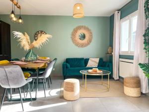 ein Wohnzimmer mit einem Tisch und einem blauen Sofa in der Unterkunft Maison 6 personnes - Etaples in Étaples