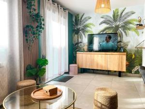 ein Wohnzimmer mit einem TV auf einem hölzernen Entertainment-Center in der Unterkunft Maison 6 personnes - Etaples in Étaples