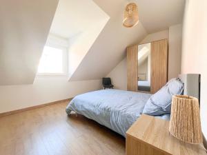ein Schlafzimmer mit einem Bett und einem Spiegel in der Unterkunft Maison 6 personnes - Etaples in Étaples