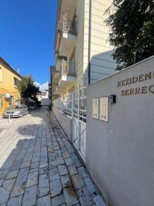 a building with a sign on the side of a street at Riva'S Apartament in Shkodër