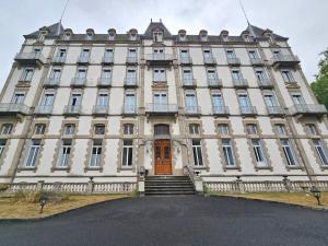 a large building with a staircase in front of it at Solovergne - Charme et confort en Auvergne in Saint-Nectaire