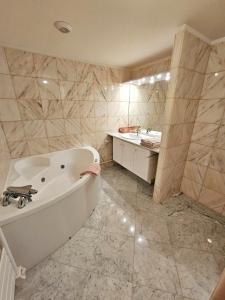 a bathroom with a bath tub and a sink at Solovergne - Charme et confort en Auvergne in Saint-Nectaire +16 photos