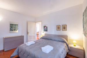 una camera da letto con un letto con due asciugamani bianchi di Al Poggio Della Capannina a Castellina in Chianti