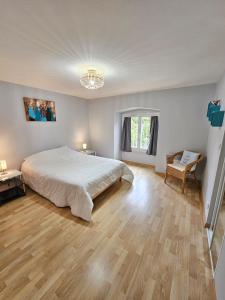 a bedroom with a large bed and a wooden floor at Solovergne - Charme et confort en Auvergne in Saint-Nectaire