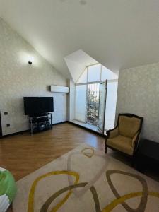 a large living room with a television and a chair at Quba Village Villa in Quba
