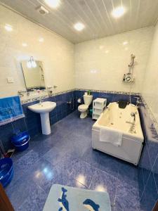 a bathroom with a sink and a tub and a toilet at Quba Village Villa in Quba