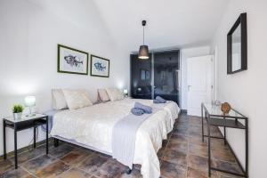 a bedroom with a large bed and two tables at Casa Amanecer 3 in Mácher