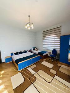 a bedroom with a blue bed and a large carpet at Quba Village Villa in Quba