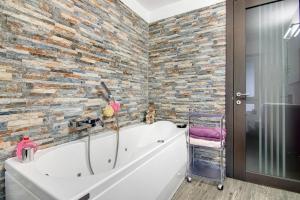 a bathroom with a tub and a stone wall at Belcantone in Grandola ed Uniti +13 photos