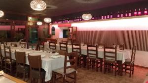 a dining room with white tables and wooden chairs at Hostal Cabrerès in Cantonigros +24 photos