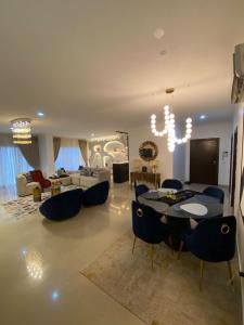 Una sala de estar con una mesa y sillas azules. en Maison Apartment, en Lagos