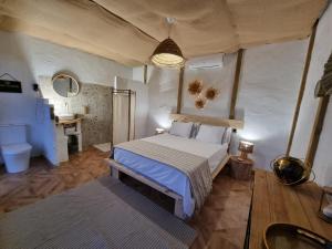 a bedroom with a large bed and a bathroom at Glamping Cabaña Suite Los Almendros in Málaga