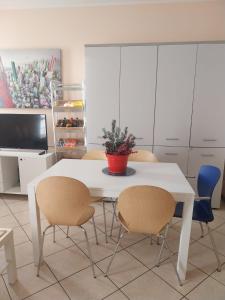 a white dining room table with two chairs and a potted plant at Casa Vacanze La Torre in Orio al Serio +9 photos