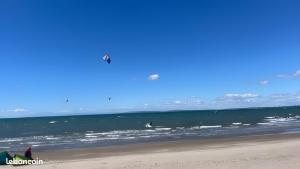 Een paar mensen op het strand die een vlieger oplaten. bij Location Mobilhome Agde in Agde +1 foto