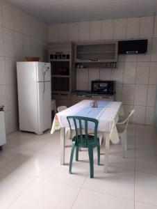 a kitchen with a table and a refrigerator at Ninho dos falcões in Nobres