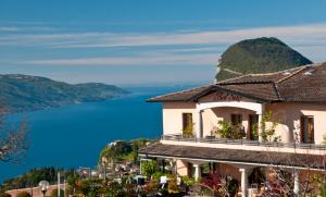 a building on a hill with a view of the water at Hotel Garni Bel Sito in Tremosine Sul Garda
