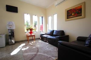 ein Wohnzimmer mit einem Sofa, einem Tisch und Fenstern in der Unterkunft Glória Hotel in Olímpia